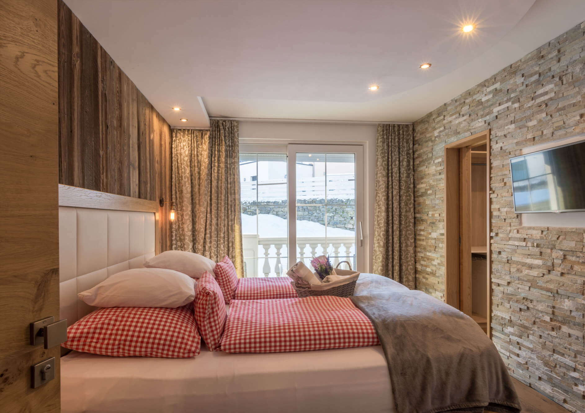Deluxe Doppelzimmer mit Steinwand, Altholz und karierter Bettwäsche